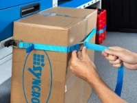 Mit Spanngurt an der Einrichtung fixiertes Material im Fahrzeug